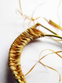 Brass ring woven with grass