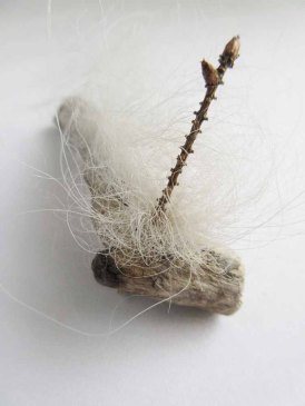 the twig was a found tool that i used to push the wool in with, left it in to hold the wool in place